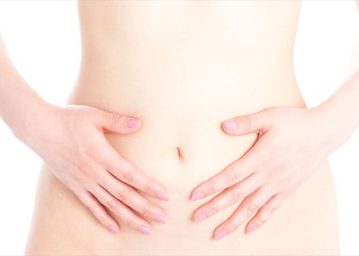 お腹を押さえる女性